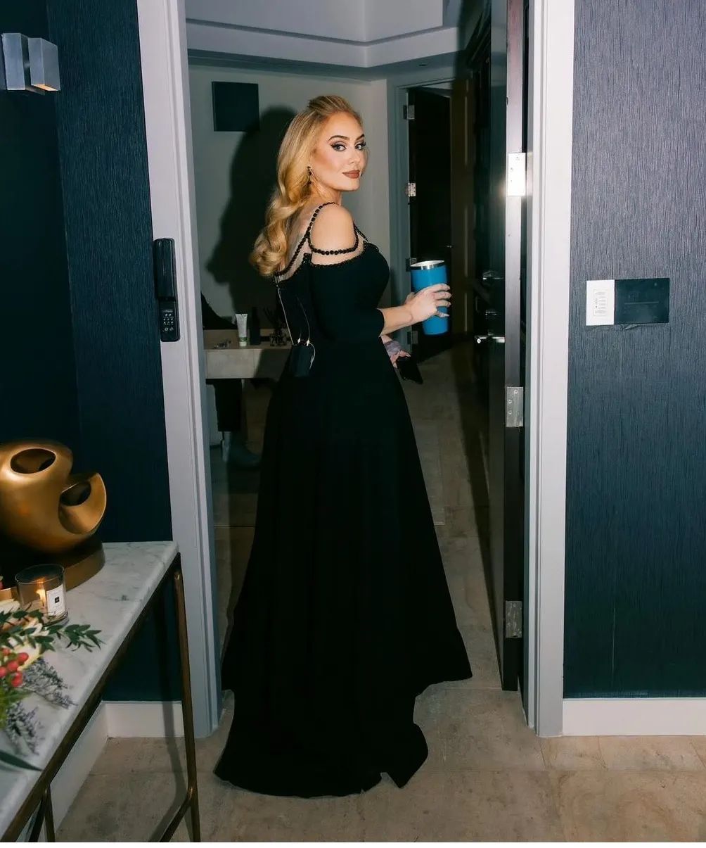 On her 30th weekend in Las Vegas, Adele opted for a custom GEORGES HOBEIKA dress. The black gown is fashioned from double crepe silk, featuring an off-the-shoulder design and a defined waist. The addition of intricately embroidered black Swarovski studs around the neckline area imparted an air of grace and relaxed sophistication to the whole look.