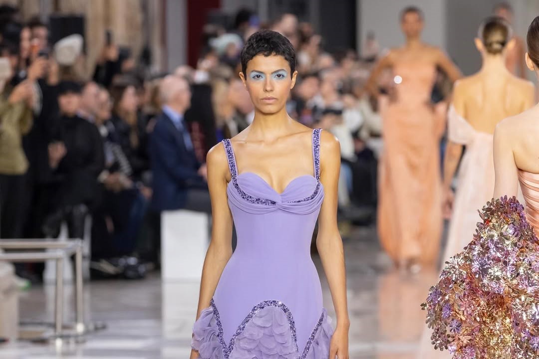 Georges Chakra SS26 CoutureA confident evolution of the Maison’s heritage, where glamour is reimagined through a modern Parisienne lens. Clean lines meet sculpted volume, blending strength with elegance. Ballooned hems, architectural sleeves, corseted bodices, and strategic draping create silhouettes defined by authority and fluid movement.